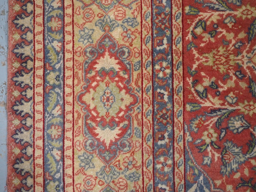An antique Anatolian Sivas hand-knotted wool rug featuring a central cream medallion surrounded by a red field with floral arabesques and multi-tiered borders. View VII