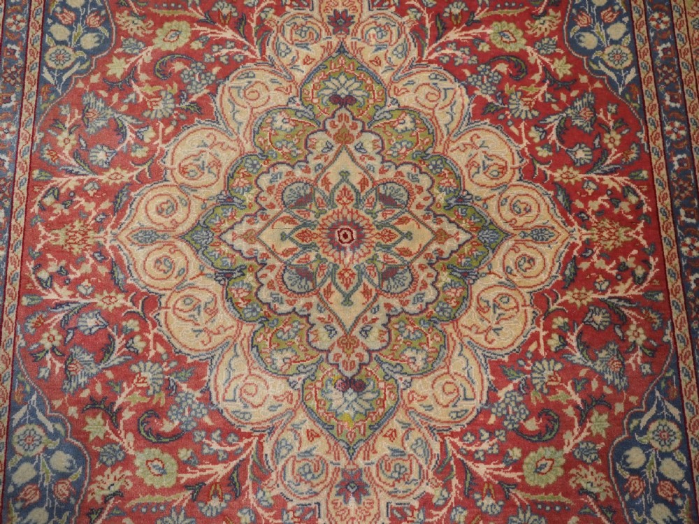 An antique Anatolian Sivas hand-knotted wool rug featuring a central cream medallion surrounded by a red field with floral arabesques and multi-tiered borders. View X