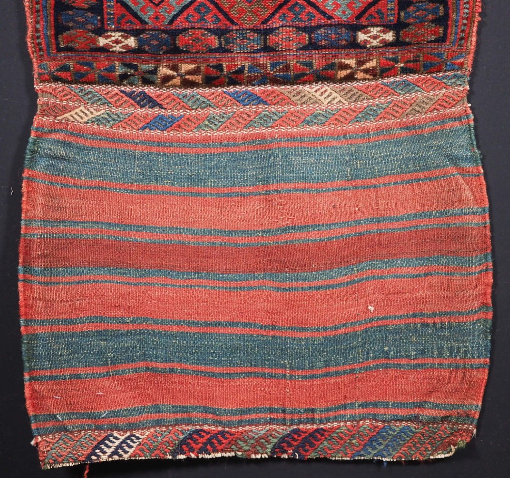 An antique Kurdish Jaf tribal bag featuring a hand-knotted diamond geometric pattern on the front and a striped plain weave backing in red, blue, and teal shades. View III