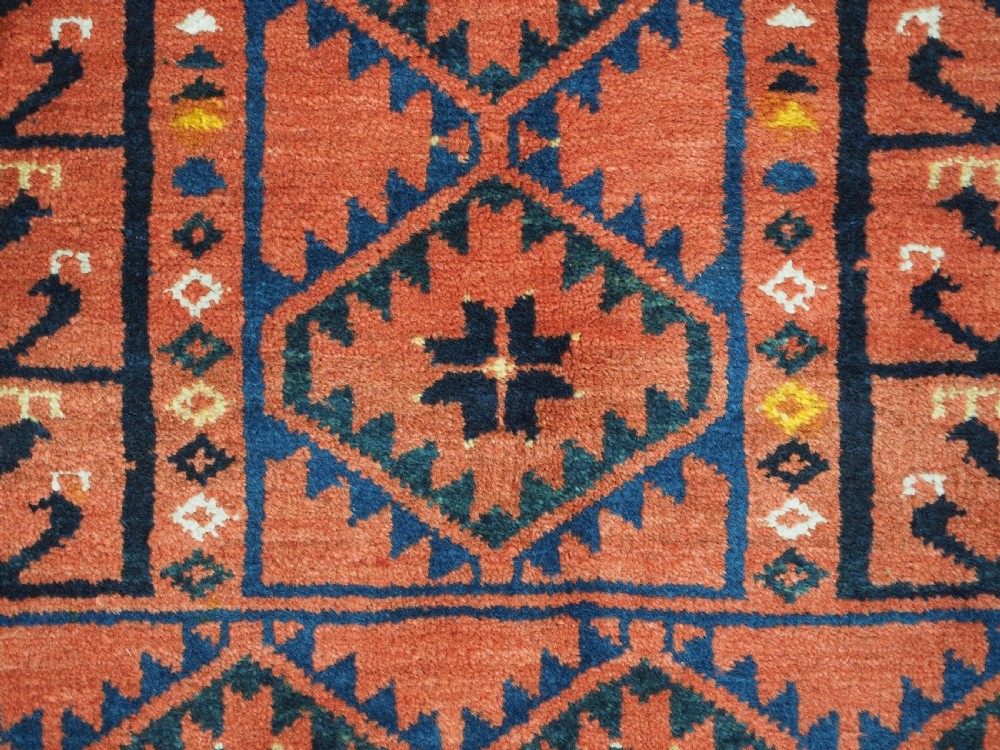 An antique rectangular hand-knotted wool Ersari Turkmen ensi rug featuring a four-panel hatchli pattern in terracotta red, dark blue, and ivory geometric motifs. View XI