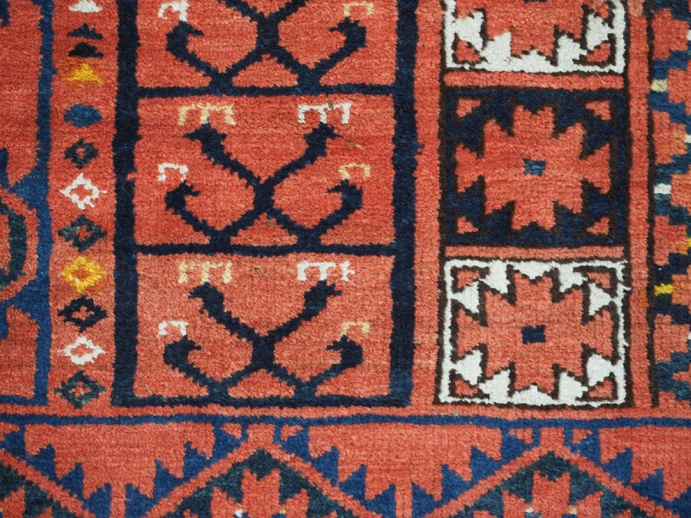 An antique rectangular hand-knotted wool Ersari Turkmen ensi rug featuring a four-panel hatchli pattern in terracotta red, dark blue, and ivory geometric motifs. View XII