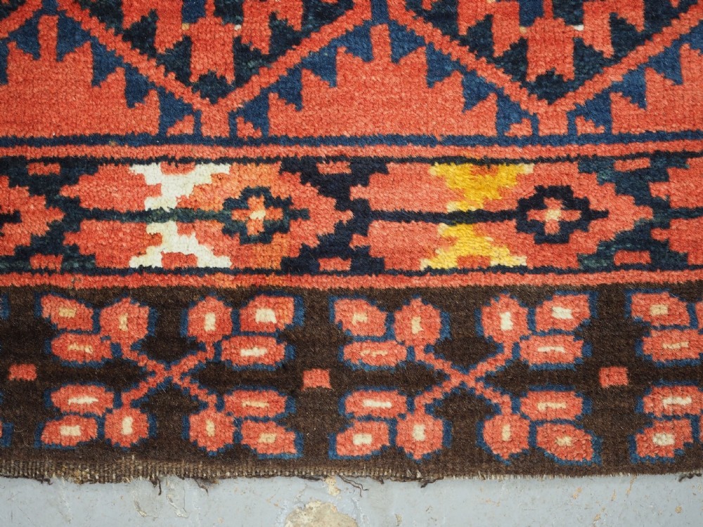 An antique rectangular hand-knotted wool Ersari Turkmen ensi rug featuring a four-panel hatchli pattern in terracotta red, dark blue, and ivory geometric motifs. View XIII