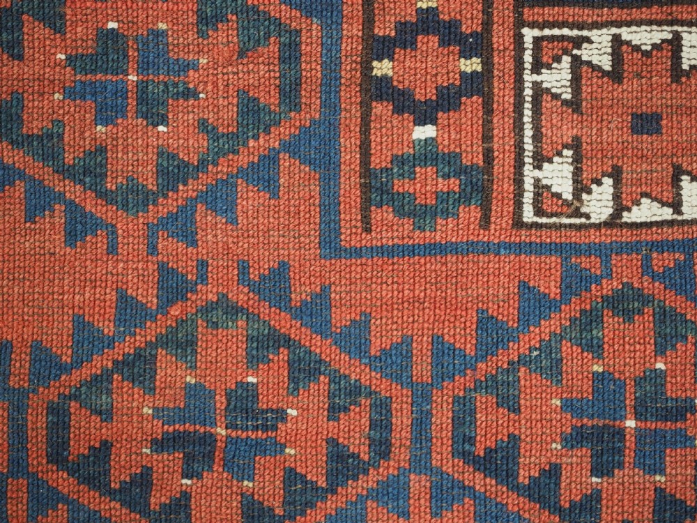An antique rectangular hand-knotted wool Ersari Turkmen ensi rug featuring a four-panel hatchli pattern in terracotta red, dark blue, and ivory geometric motifs. View XV