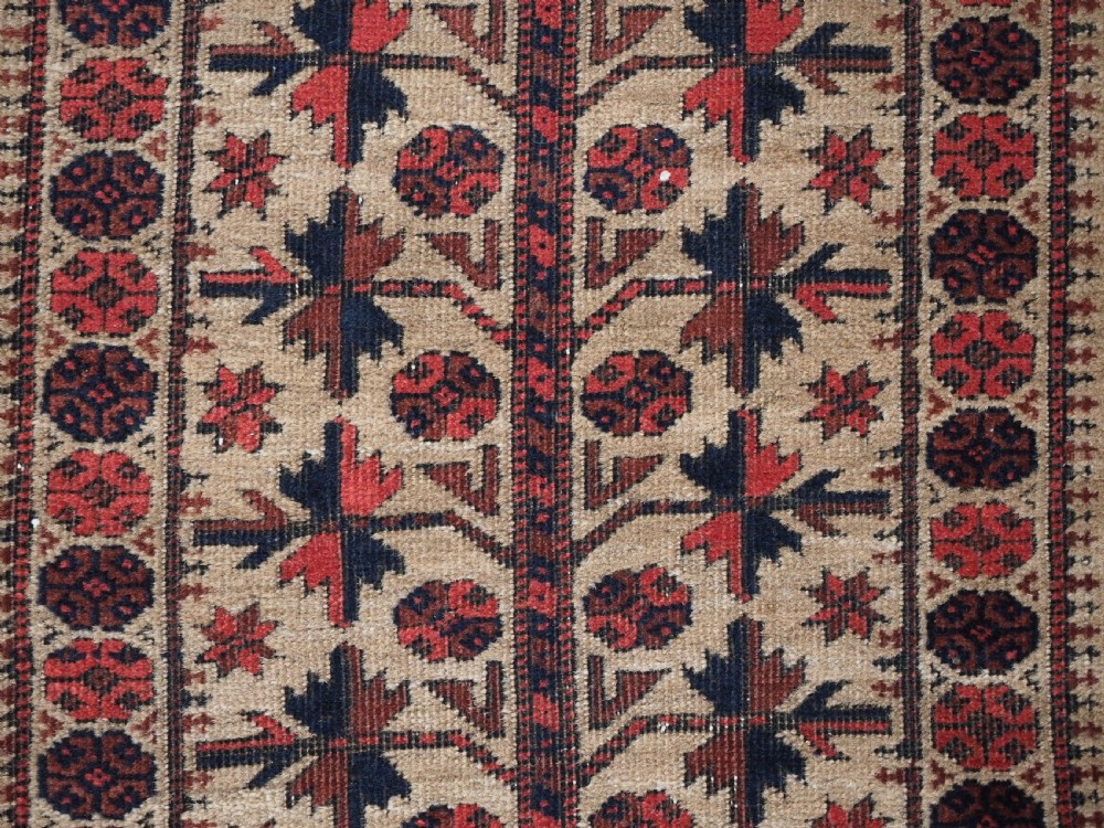 An antique Baluch wool prayer rug featuring a central mihrab arch, tree motifs, hand icons, and geometric borders in dark red, brown, and camel shades. View XI