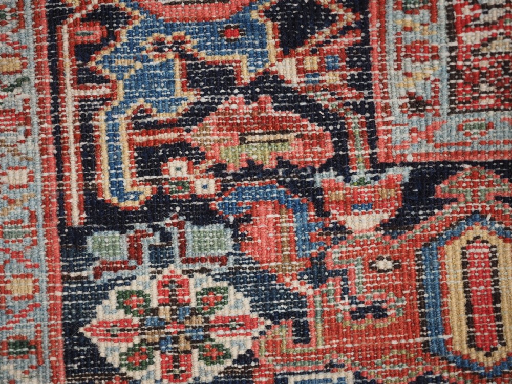 An antique hand-knotted wool Heriz carpet featuring a large central geometric medallion in rust red, navy blue, and cream surrounded by detailed geometric borders. View XVIII