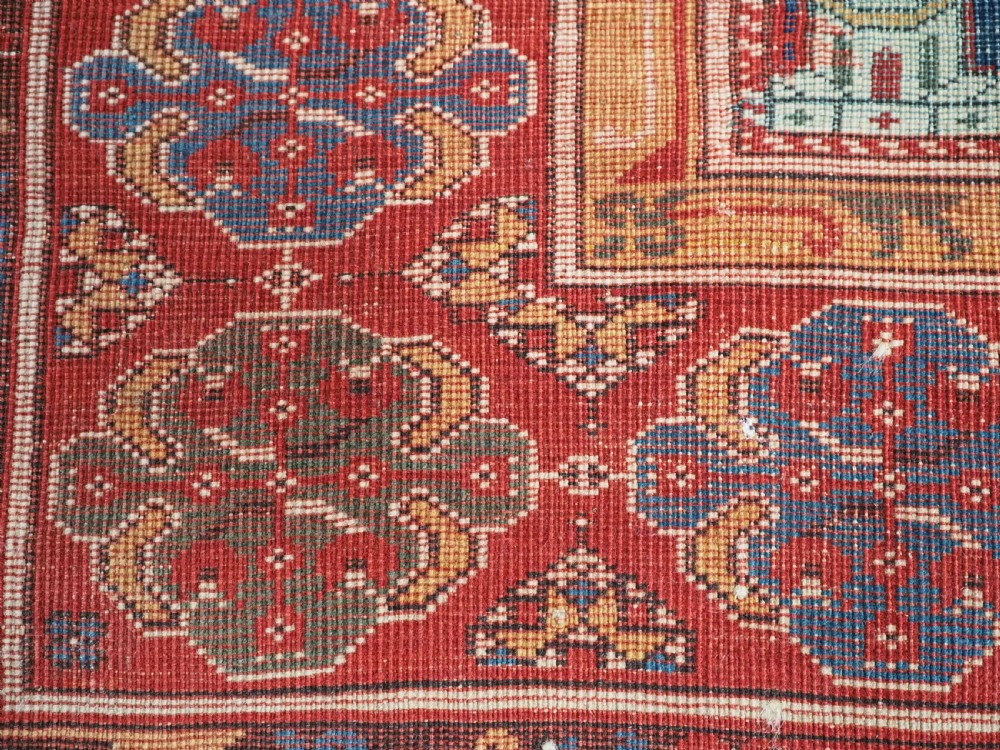 A hand-knotted wool prayer rug with a blue central column niche motif framed by beige spandrels and a red geometric border. View XVI