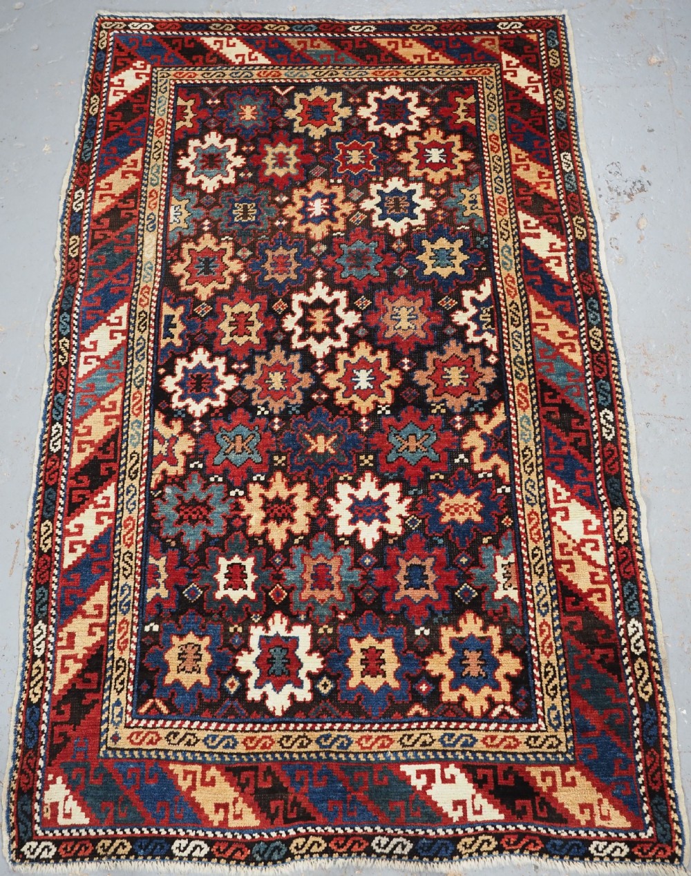ANTIQUE CAUCASIAN DAGESTAN RUG WITH BLOSSOM DESIGN, CIRCA 1880.