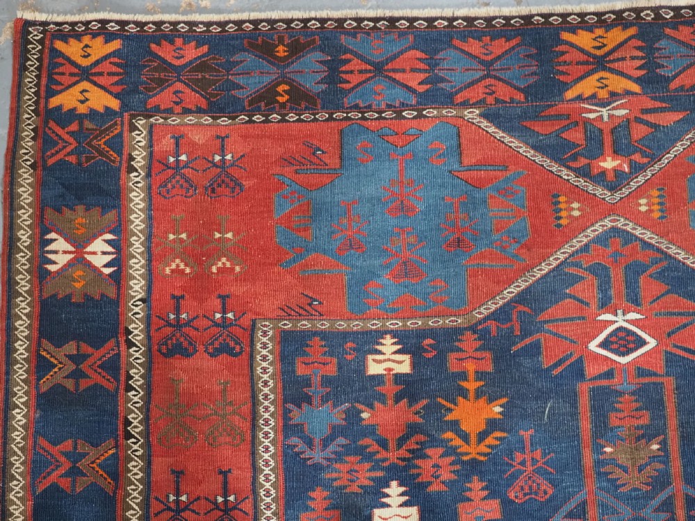 An antique flatweave Caucasian Avar kilim runner featuring geometric octagonal medallions down a navy centre field framed by terracotta and blue patterned borders. View VII