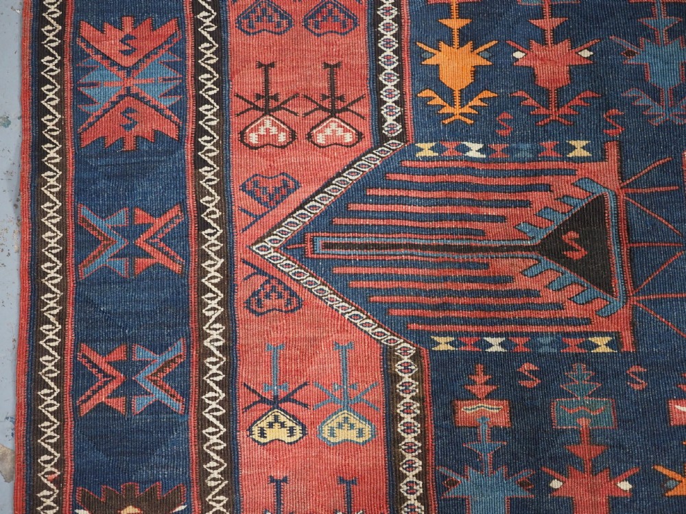 An antique flatweave Caucasian Avar kilim runner featuring geometric octagonal medallions down a navy centre field framed by terracotta and blue patterned borders. View XI