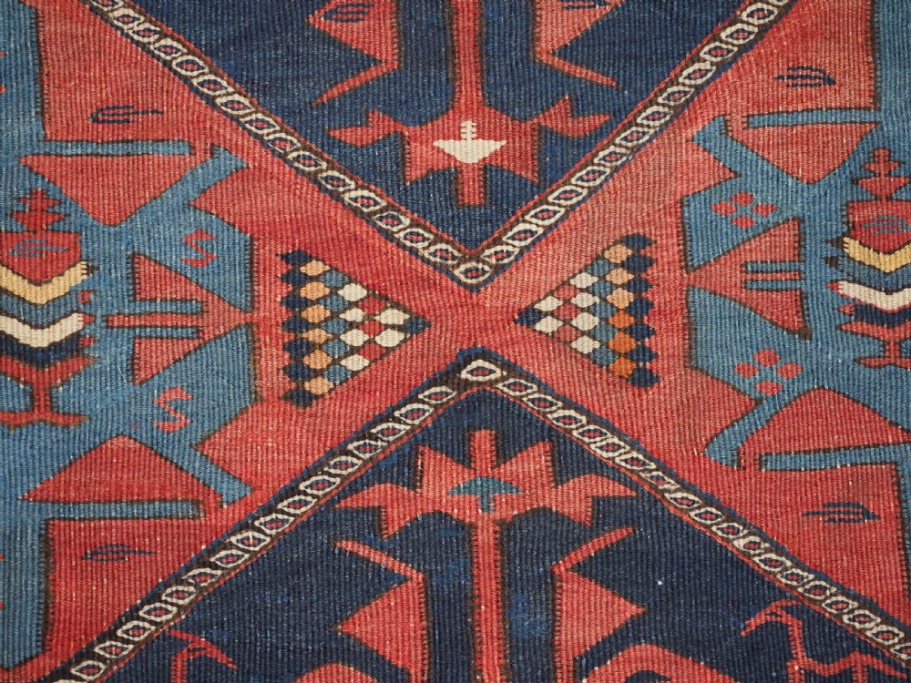 An antique flatweave Caucasian Avar kilim runner featuring geometric octagonal medallions down a navy centre field framed by terracotta and blue patterned borders. View XIII