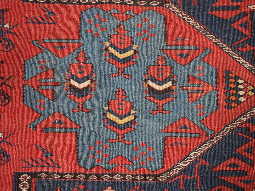 An antique flatweave Caucasian Avar kilim runner featuring geometric octagonal medallions down a navy centre field framed by terracotta and blue patterned borders. View XV