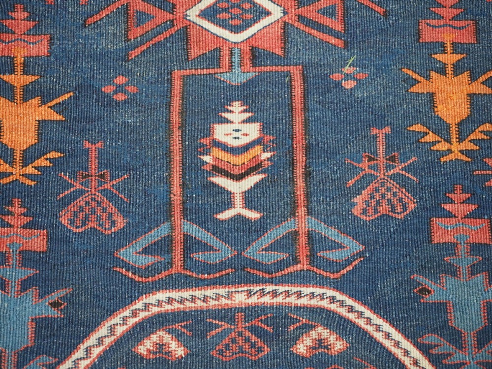 An antique flatweave Caucasian Avar kilim runner featuring geometric octagonal medallions down a navy centre field framed by terracotta and blue patterned borders. View XVI