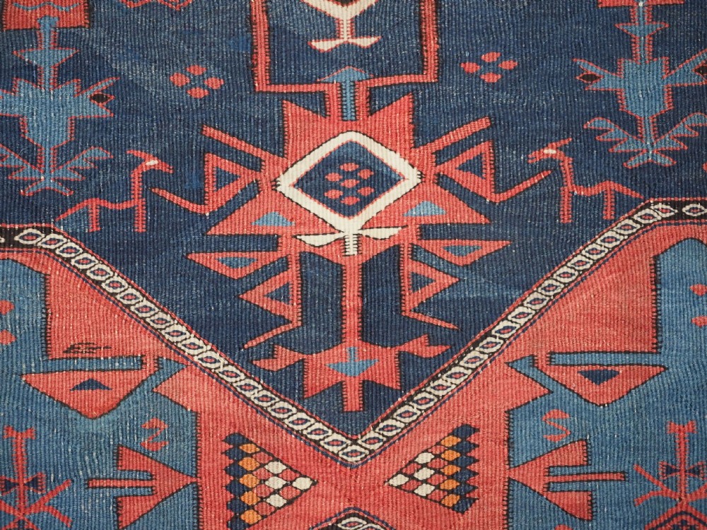 An antique flatweave Caucasian Avar kilim runner featuring geometric octagonal medallions down a navy centre field framed by terracotta and blue patterned borders. View XVII