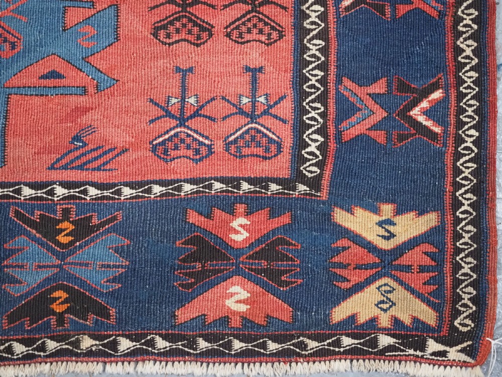 An antique flatweave Caucasian Avar kilim runner featuring geometric octagonal medallions down a navy centre field framed by terracotta and blue patterned borders. View XVIII