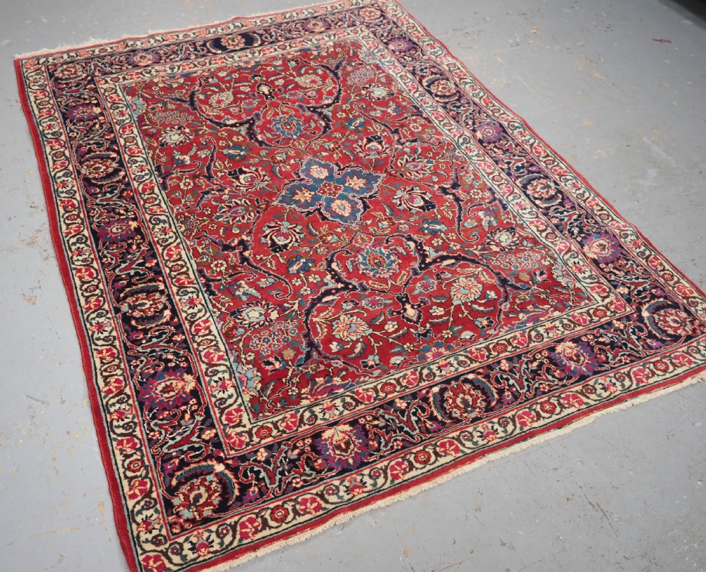A hand-knotted Tabriz wool rug featuring a blue central star medallion surrounded by floral scrollwork in red, cream, and navy blue with an ornate border. View II