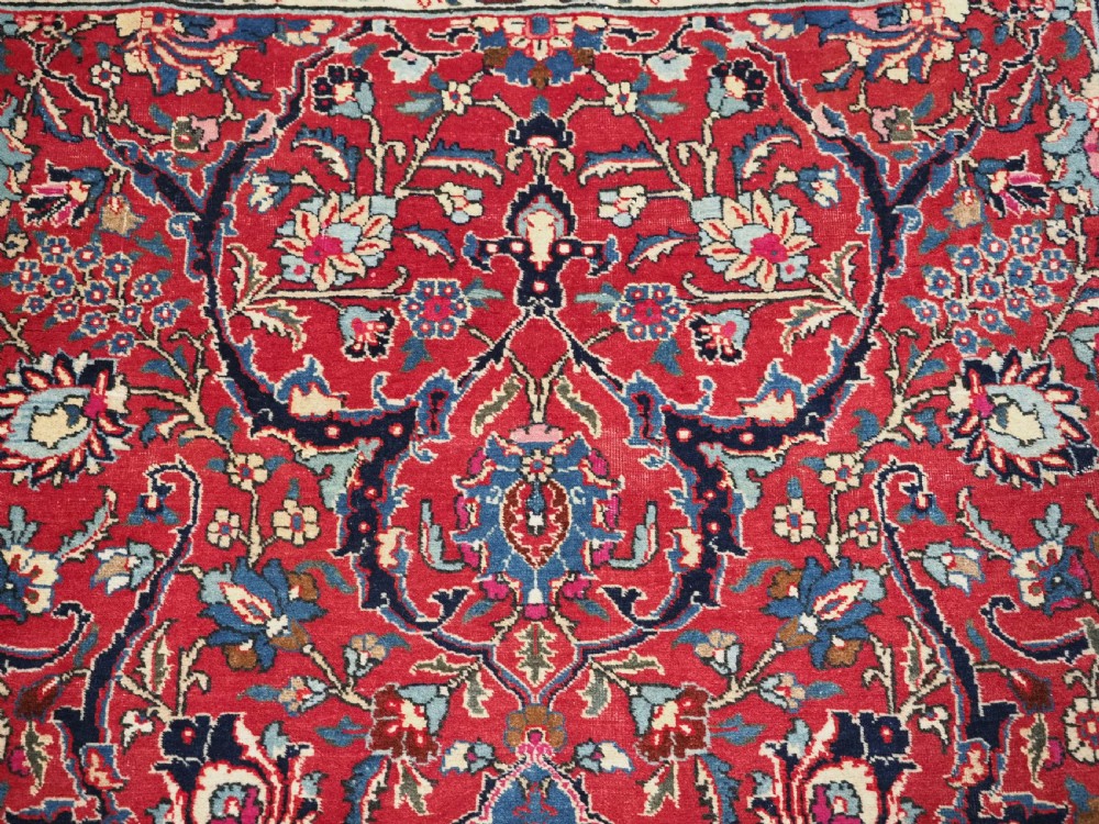 A hand-knotted Tabriz wool rug featuring a blue central star medallion surrounded by floral scrollwork in red, cream, and navy blue with an ornate border. View VIII