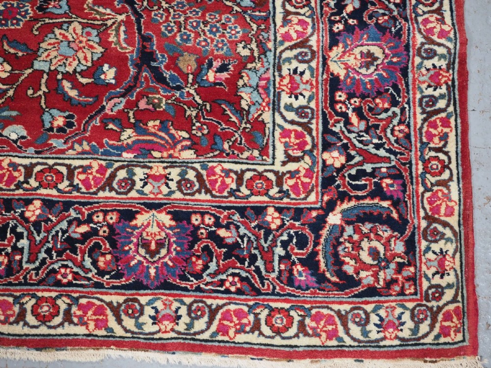 A hand-knotted Tabriz wool rug featuring a blue central star medallion surrounded by floral scrollwork in red, cream, and navy blue with an ornate border. View XI