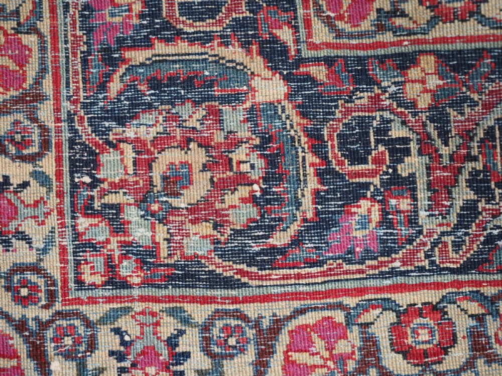 A hand-knotted Tabriz wool rug featuring a blue central star medallion surrounded by floral scrollwork in red, cream, and navy blue with an ornate border. View XII