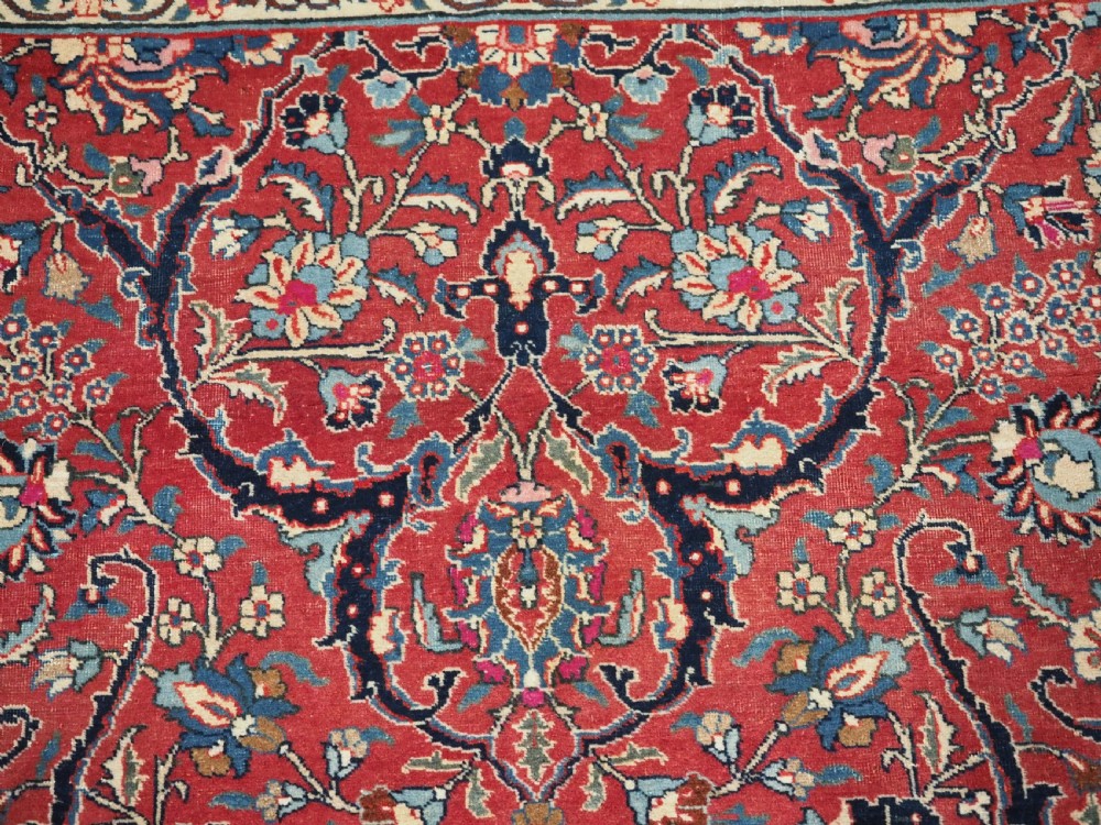 An antique hand-knotted Persian Tabriz wool rug featuring a dark navy central medallion surrounded by a red floral field and decorative navy borders. View VIII