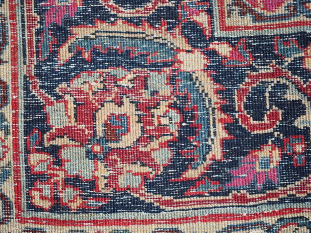 An antique hand-knotted Persian Tabriz wool rug featuring a dark navy central medallion surrounded by a red floral field and decorative navy borders. View XII