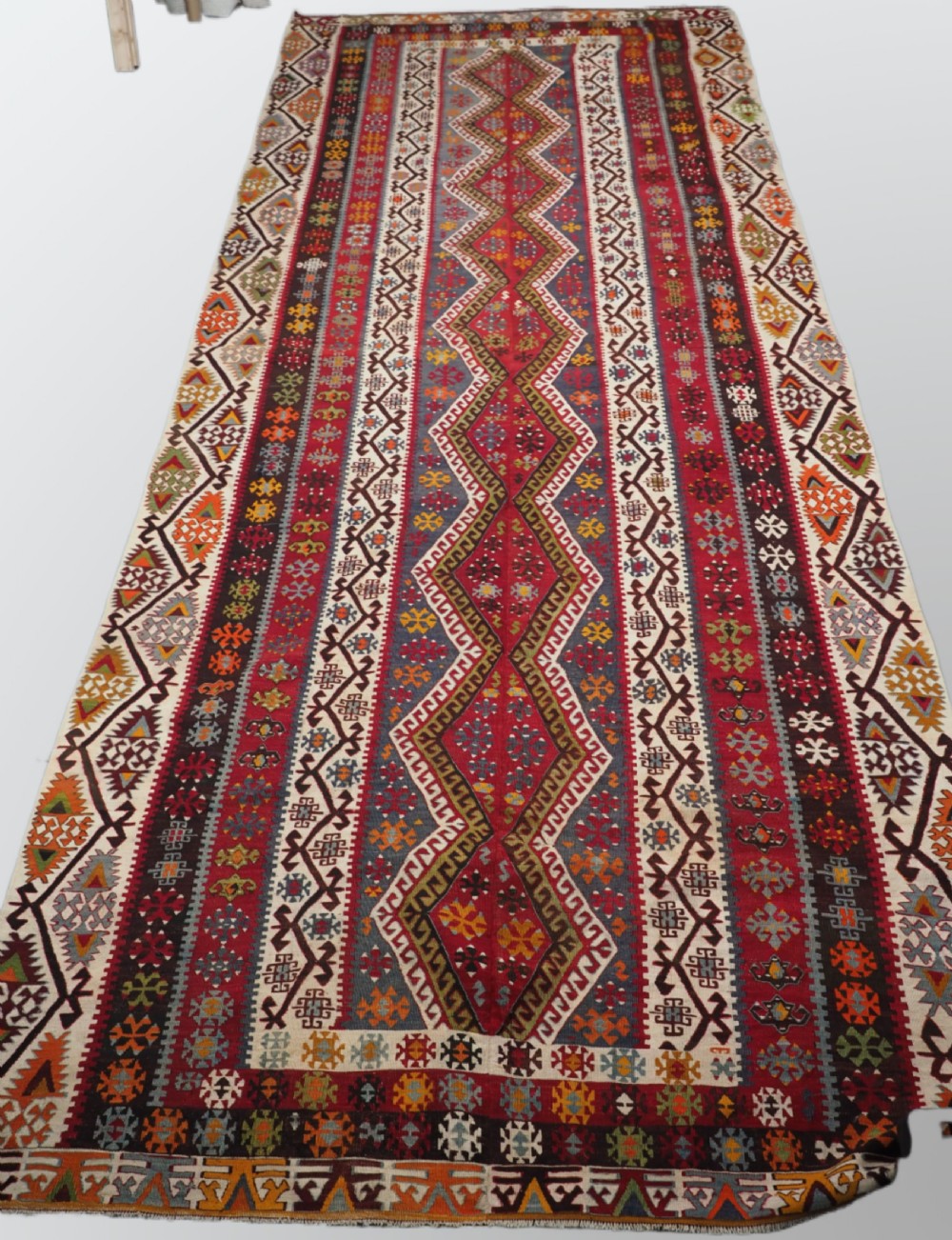 A large flatwoven antique Turkish Kayseri wool kilim rug featuring central red diamond medallions surrounded by geometric patterned borders.