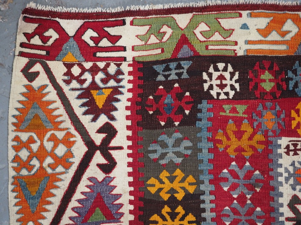 A large flatwoven antique Turkish Kayseri wool kilim rug featuring central red diamond medallions surrounded by geometric patterned borders. View VIII