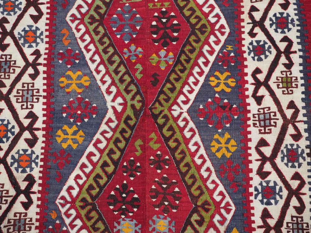 A large flatwoven antique Turkish Kayseri wool kilim rug featuring central red diamond medallions surrounded by geometric patterned borders. View XIII