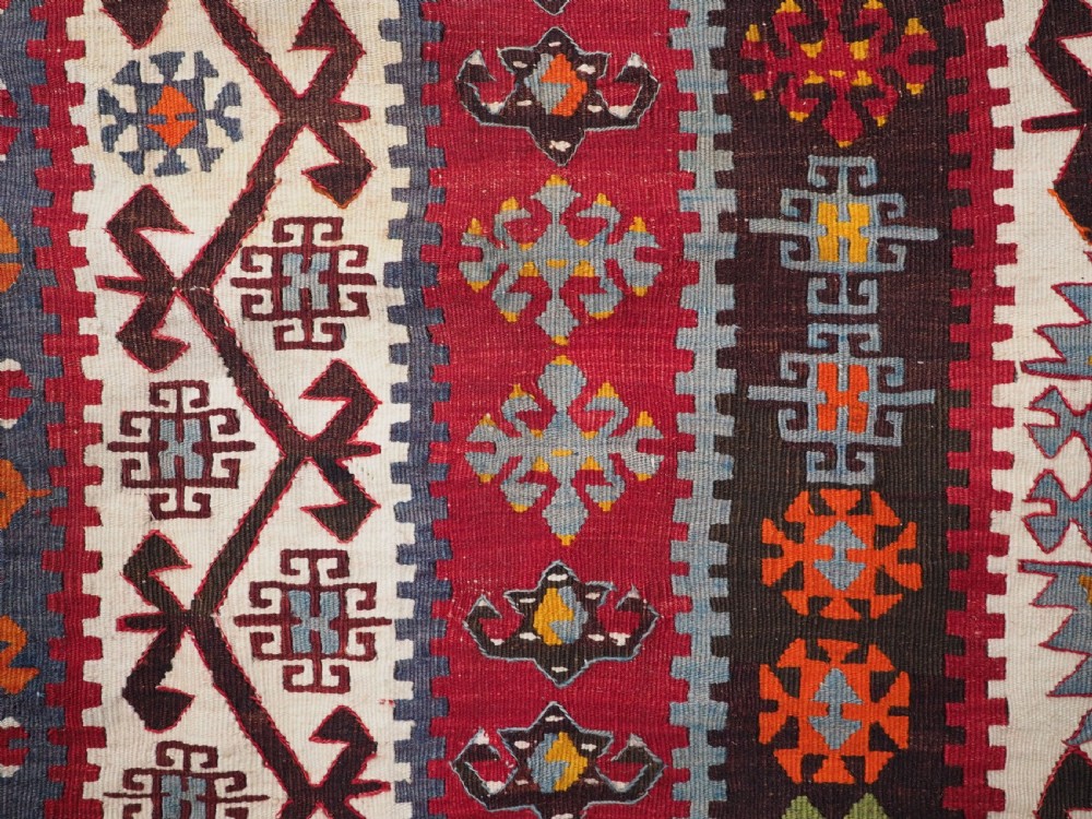 A large flatwoven antique Turkish Kayseri wool kilim rug featuring central red diamond medallions surrounded by geometric patterned borders. View XIV