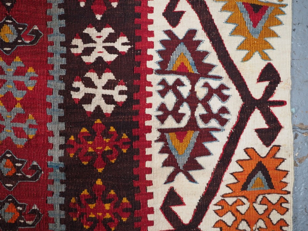 A large flatwoven antique Turkish Kayseri wool kilim rug featuring central red diamond medallions surrounded by geometric patterned borders. View XV