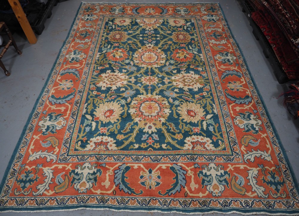 A hand-knotted Persian Mahal carpet with a central blue field decorated with floral palmettes and framed by a wide terracotta border. View III