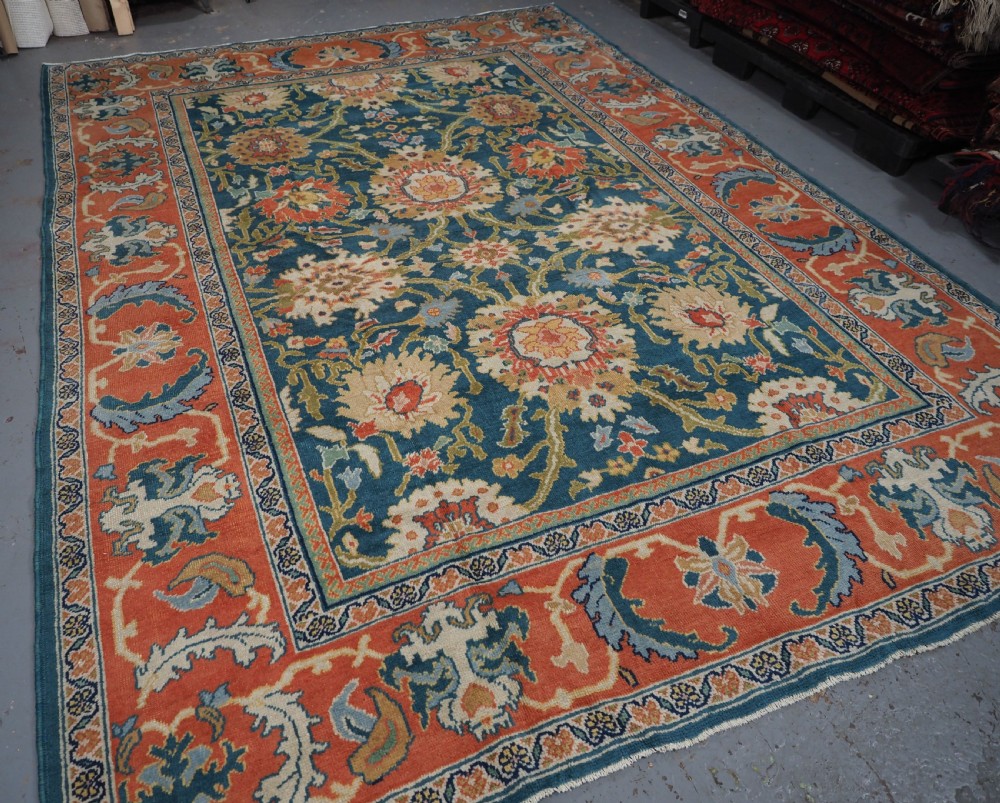 A hand-knotted Persian Mahal carpet with a central blue field decorated with floral palmettes and framed by a wide terracotta border. View IV