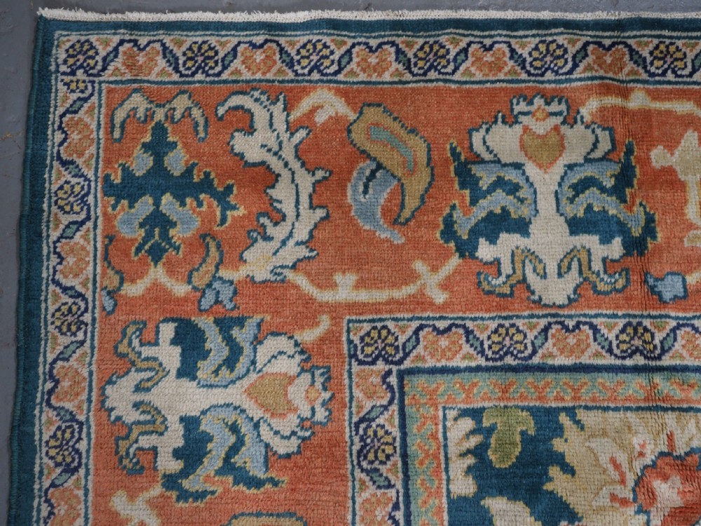 A hand-knotted Persian Mahal carpet with a central blue field decorated with floral palmettes and framed by a wide terracotta border. View VIII