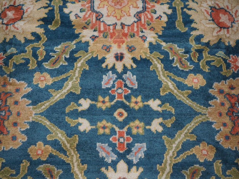 A hand-knotted Persian Mahal carpet with a central blue field decorated with floral palmettes and framed by a wide terracotta border. View XI