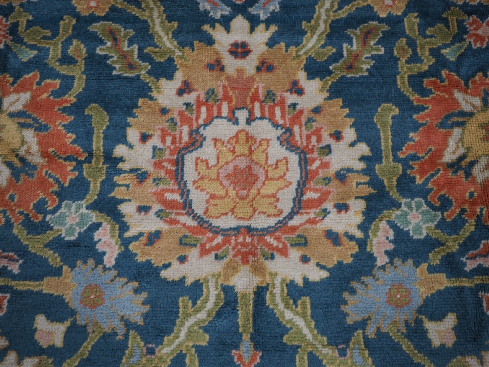 A hand-knotted Persian Mahal carpet with a central blue field decorated with floral palmettes and framed by a wide terracotta border. View XII