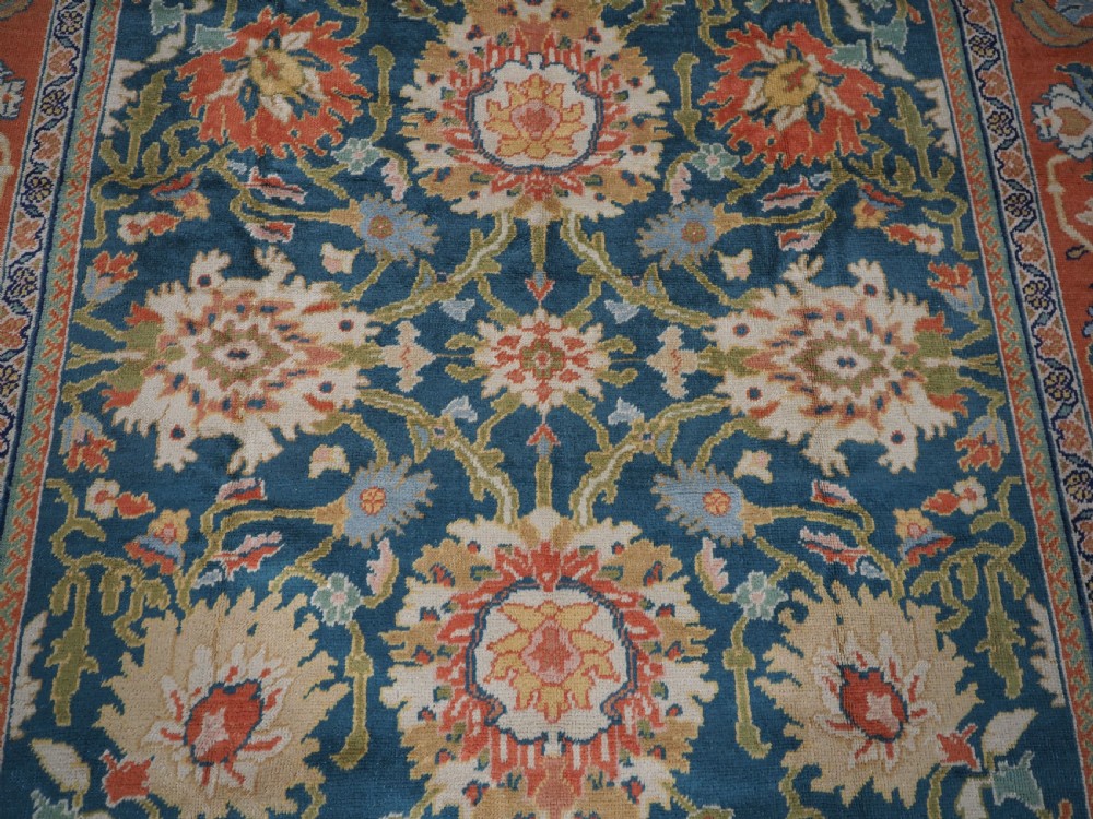 A hand-knotted Persian Mahal carpet with a central blue field decorated with floral palmettes and framed by a wide terracotta border. View XIII