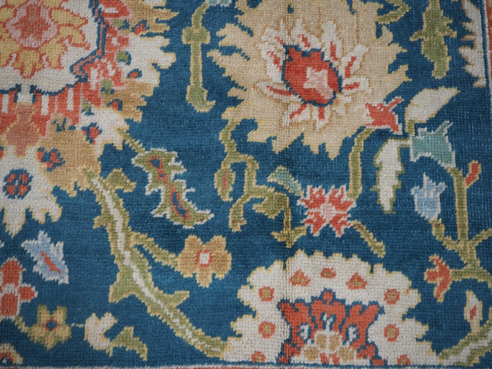 A hand-knotted Persian Mahal carpet with a central blue field decorated with floral palmettes and framed by a wide terracotta border. View XV