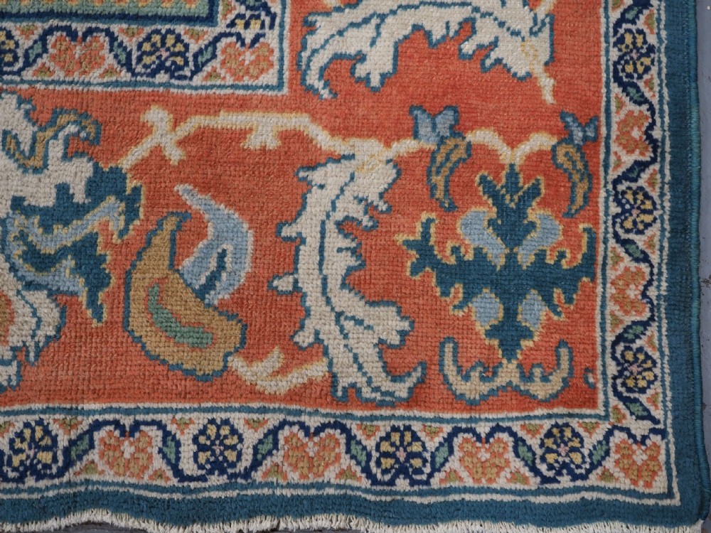 A hand-knotted Persian Mahal carpet with a central blue field decorated with floral palmettes and framed by a wide terracotta border. View XVI