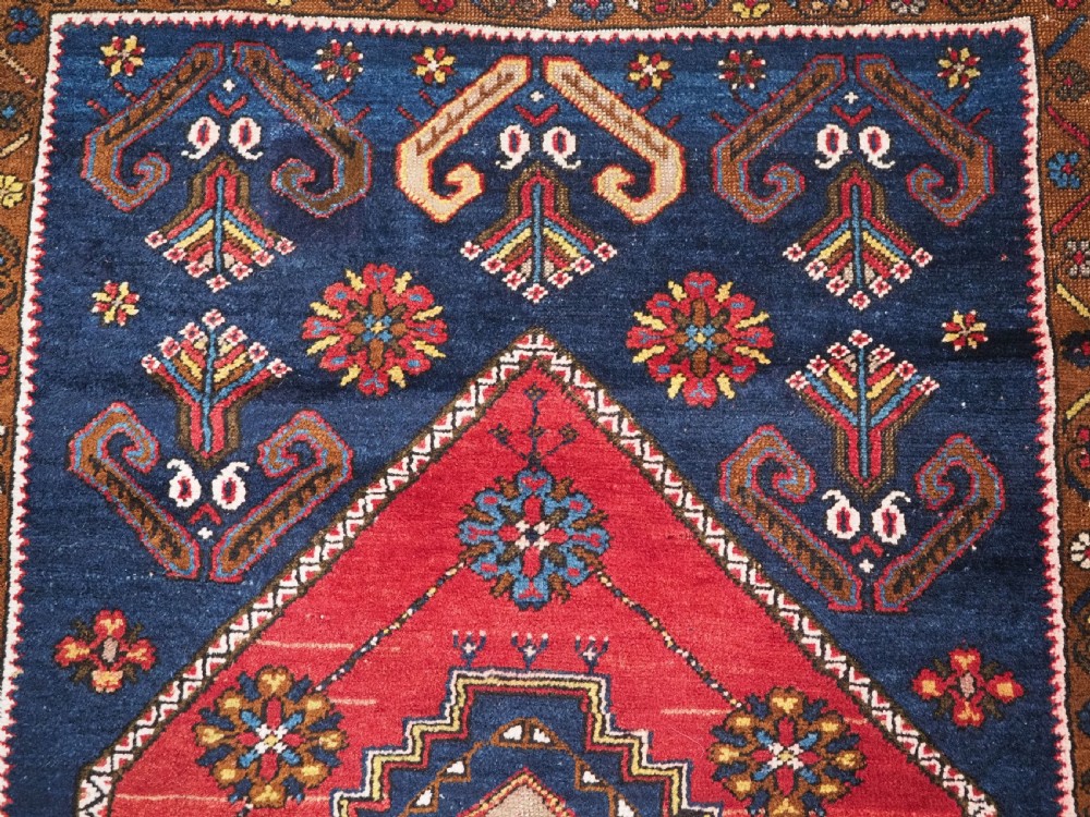 An antique hand-knotted Turkish Yahyali wool rug featuring a central geometric medallion design in red, cream, and navy blue with ornate floral borders. View VIII