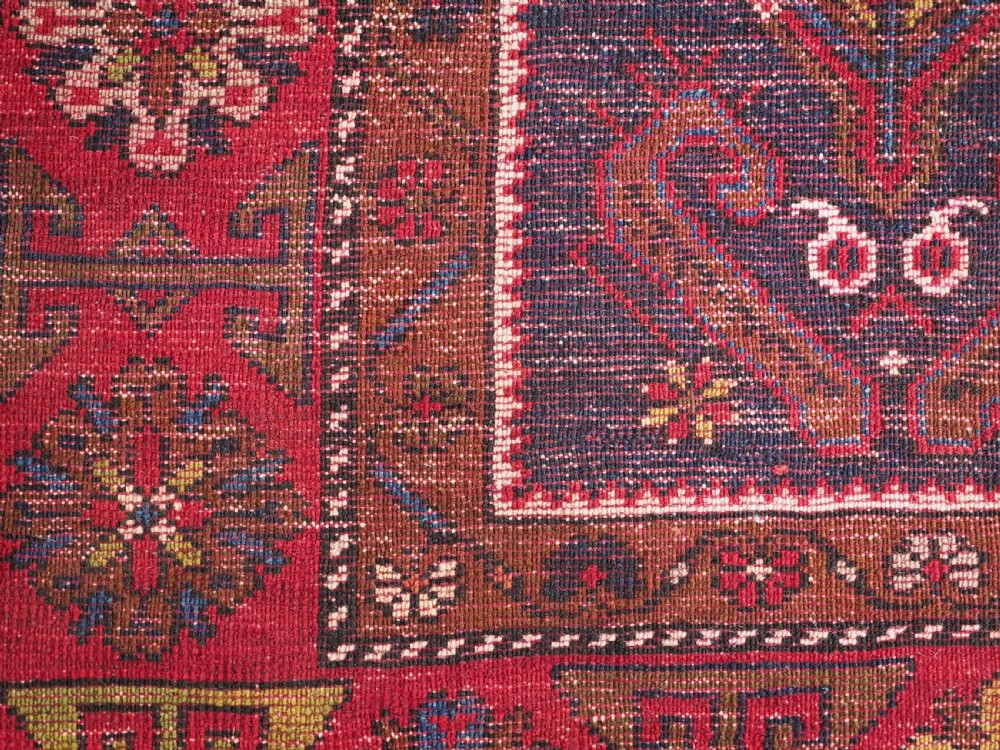 An antique hand-knotted Turkish Yahyali wool rug featuring a central geometric medallion design in red, cream, and navy blue with ornate floral borders. View XII