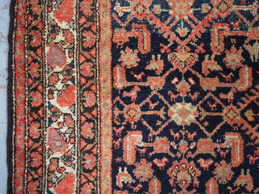 An antique Persian Malayer hand-knotted wool rug featuring an intricate all-over Herati lattice pattern on a dark navy blue field surrounded by multi-layered terracotta floral borders. View VII