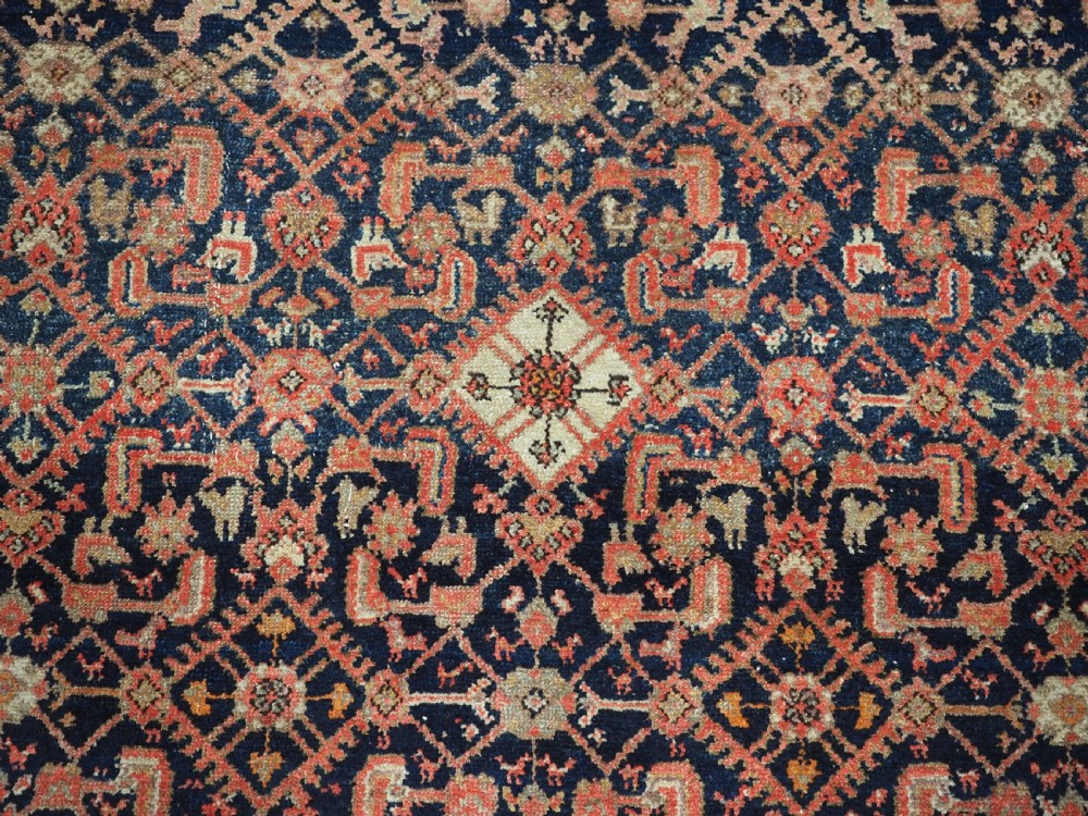 An antique Persian Malayer hand-knotted wool rug featuring an intricate all-over Herati lattice pattern on a dark navy blue field surrounded by multi-layered terracotta floral borders. View IX