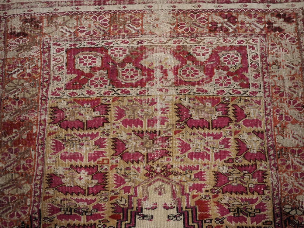 An antique Turkish Ghiordes prayer rug featuring a cream central niche framed by multi-banded red and burgundy patterned borders. View VIII