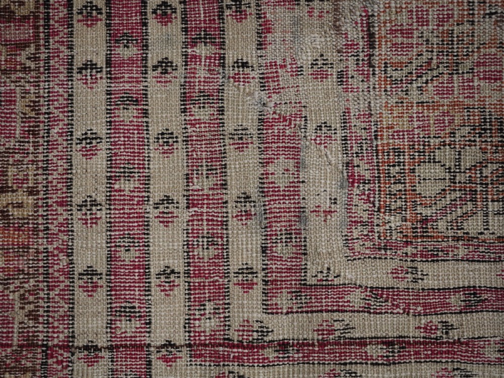An antique Turkish Ghiordes prayer rug featuring a cream central niche framed by multi-banded red and burgundy patterned borders. View XIII