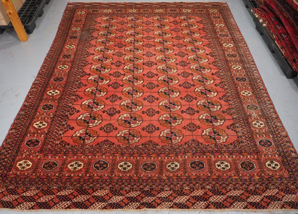 ANTIQUE TEKKE TURKMEN MAIN CARPET IN A SOFT WARM PINK / RED COLOUR, CIRCA 1900.
