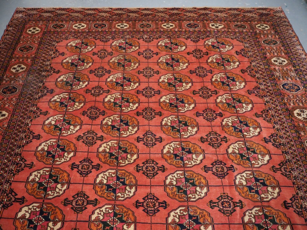 ANTIQUE TEKKE TURKMEN MAIN CARPET IN A SOFT WARM PINK / RED COLOUR, CIRCA 1900. View III