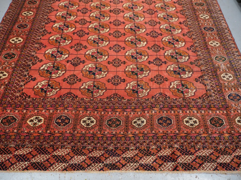 ANTIQUE TEKKE TURKMEN MAIN CARPET IN A SOFT WARM PINK / RED COLOUR, CIRCA 1900. View V