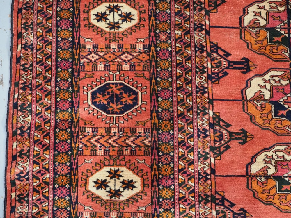 ANTIQUE TEKKE TURKMEN MAIN CARPET IN A SOFT WARM PINK / RED COLOUR, CIRCA 1900. View VII