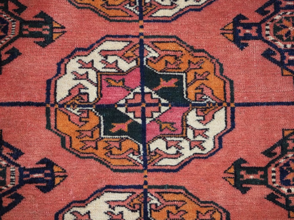 ANTIQUE TEKKE TURKMEN MAIN CARPET IN A SOFT WARM PINK / RED COLOUR, CIRCA 1900. View X