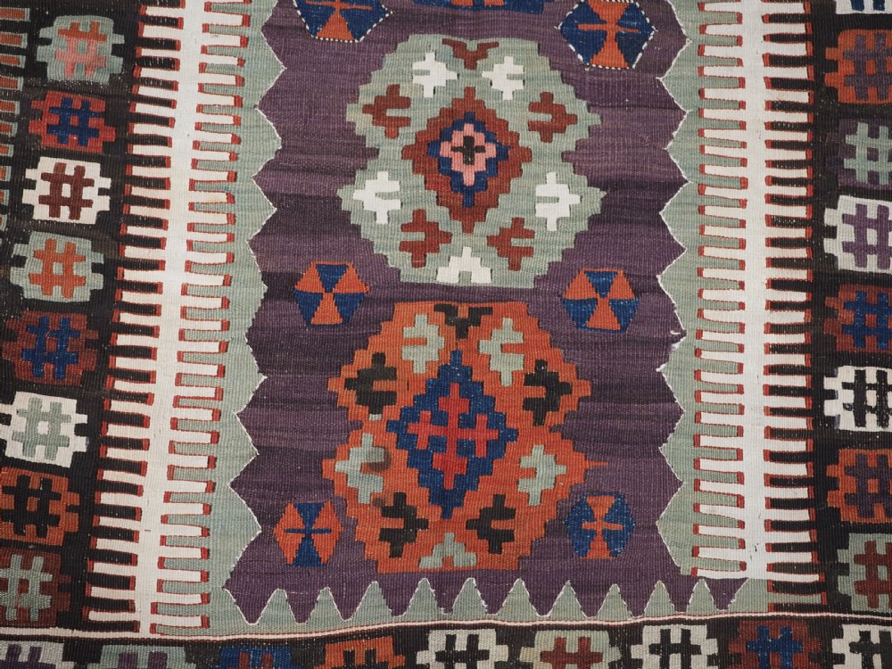 An antique handwoven Turkish Obruk kilim rug featuring a central mihrab niche motif surrounded by geometric borders in terracotta red, dark blue, green, and dark brown. View XI