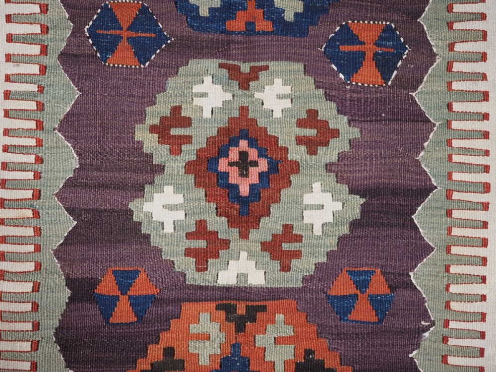 An antique handwoven Turkish Obruk kilim rug featuring a central mihrab niche motif surrounded by geometric borders in terracotta red, dark blue, green, and dark brown. View XII
